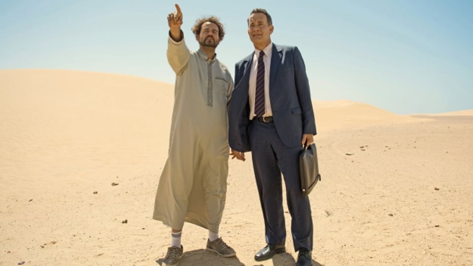 Fahrer Yousef (Alexander Black, links) zeigt Alan Clay (Tom Hanks) Saudi-Arabien.