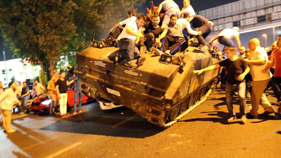 Demonstranten stürmen einen Panzer der Armee
