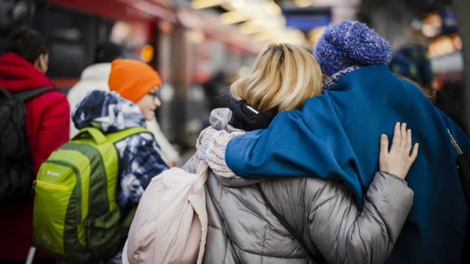 Eine Frau aus der Ukraine wird nach ihrer Ankunft mit ihrer Familie am Hauptbahnhof Zürich empfangen.