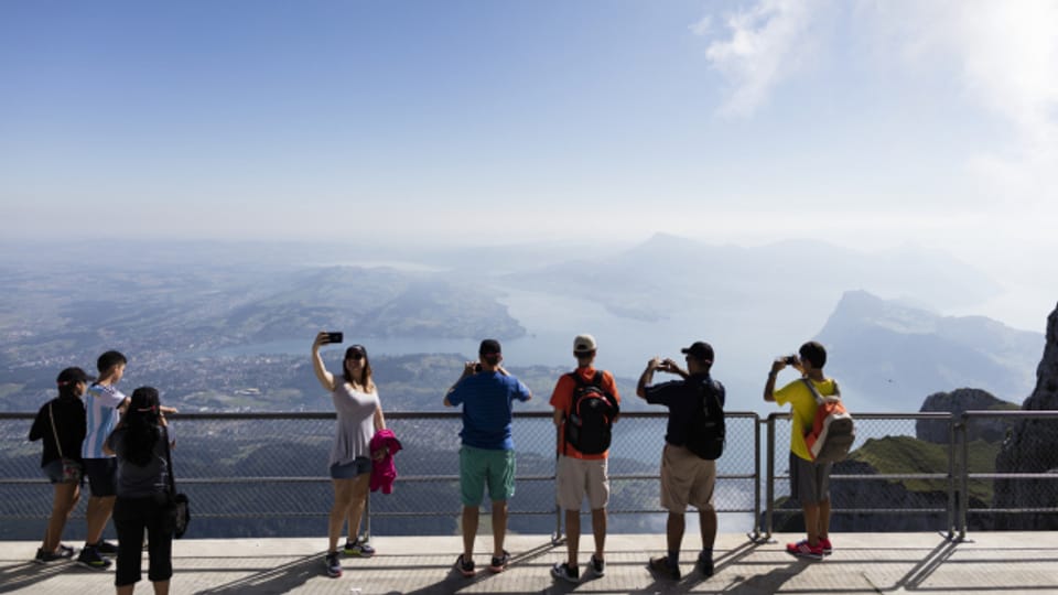 Tourist:innen auf dem Aussichtspunkt auf dem Pilatus mit Sicht auf den Vierwaldstaettersee.