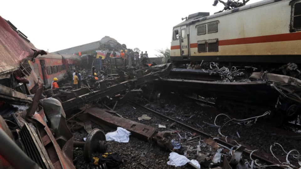 Nach der Kollision mehrerer Züge in Indien räumen Rettungskräfte die Unglücksstelle.