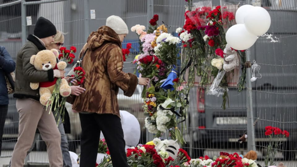 Menschen bringen Blumen zum Konzertsaal der Krokus-Stadthalle am Stadtrand von Moskau. Beim Terroranschlag sind mehr als 115 Menschen getötet worden.