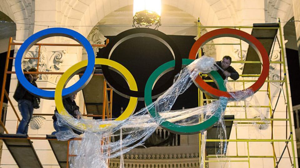 Die olympischen Ringe werden am Bahnhof von Sotschi montiert.