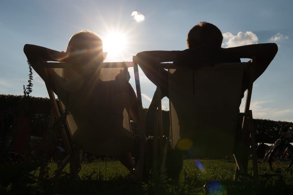 Zwei Menschen sitzen ruhig in der Sonne.