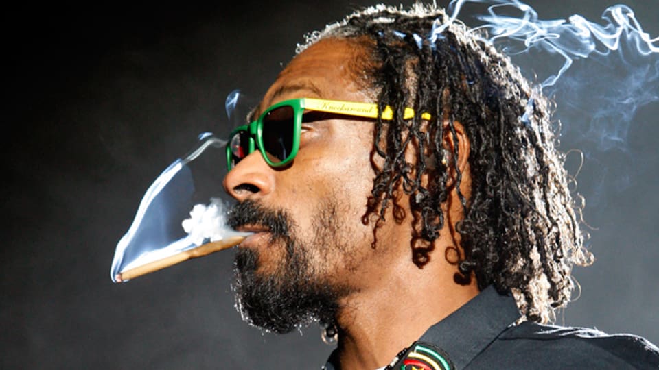 Snoop Dogg rauchend auf der Bühne.