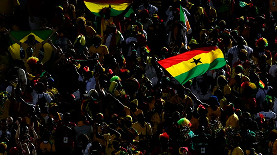 Ghanaische Fussballfans schwenken die Landesflagge.