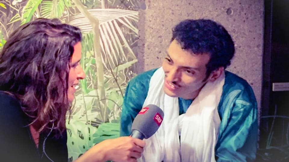Ein etwas scheu aber charmant wirkender Bombino bittet Rahel Giger im Interview, nach einem gelungen Konzert im Tropenhaus Wolhusen, man möge sein Volk, die Tuareg, nicht vergessen.