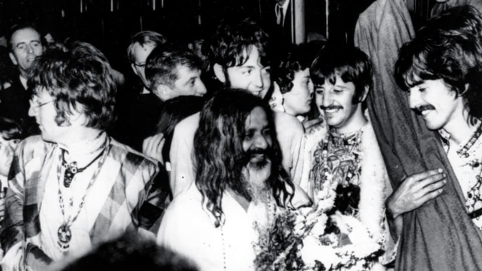 Die Beatles empfangen hier am 26. August 1967 ihren Guru Maharishi Mahesh Yogi am Bahnhof in Bangor, Wales zum Meditationswochenende.