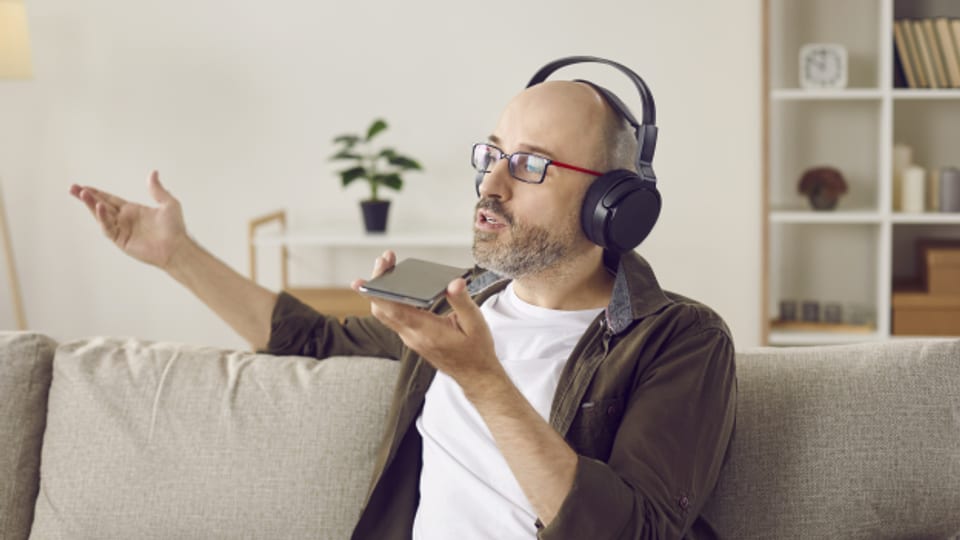 SRF Digital Redaktor Reto Widmer im Gespräch mit seinem Smartphone (haha, jk, es ist gar nicht Reto, sondern nur ein Mann auf einem Symbolbild, der ihm sehr entfernt ähnlich sieht)