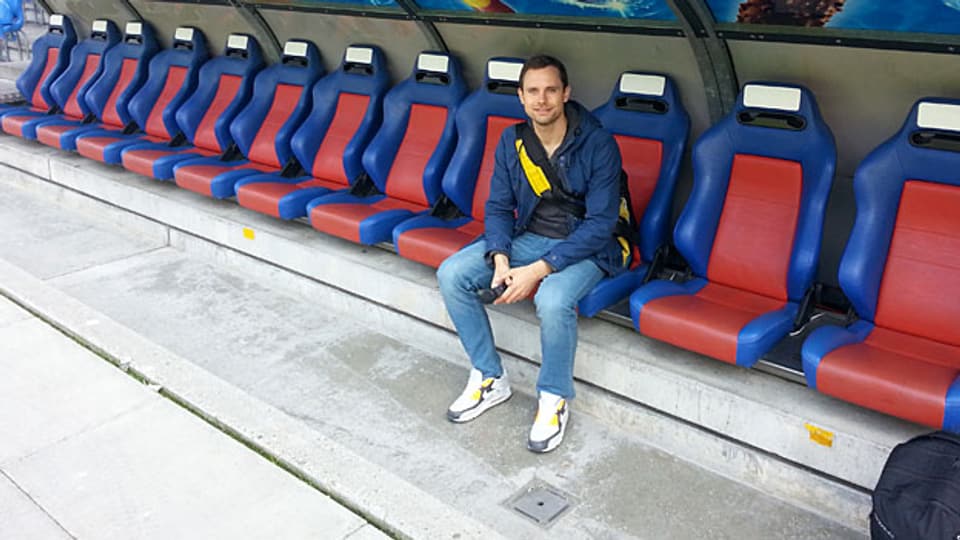 Dort wo sonst die Spieler sitzen: SRF 3 Reporter Manuel Rothmund auf der Bank des FC Basel.
