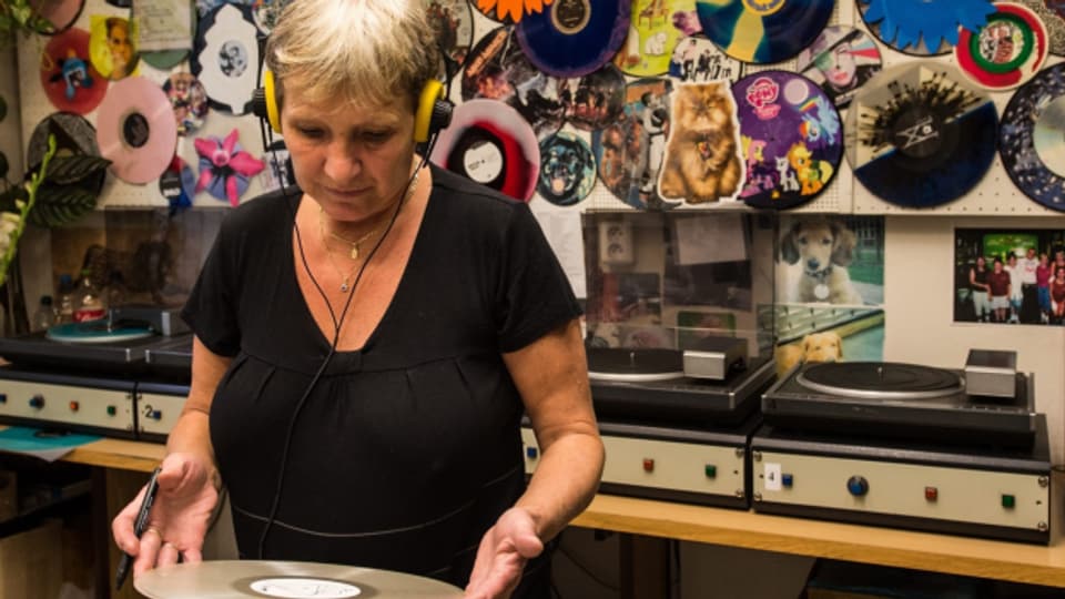 Eine Mitarbeiterin des tschechischen GZ Media Herstellers überprüft eine Schallplatte auf ihre Tonqualität.