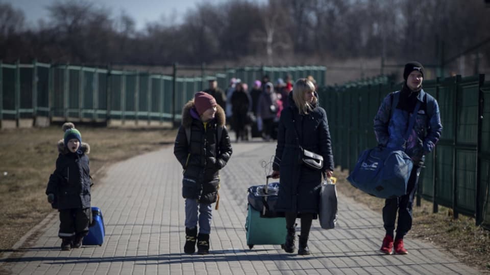Eine Mutter passiert mit ihren Kindern die Grenze nach Polen.
