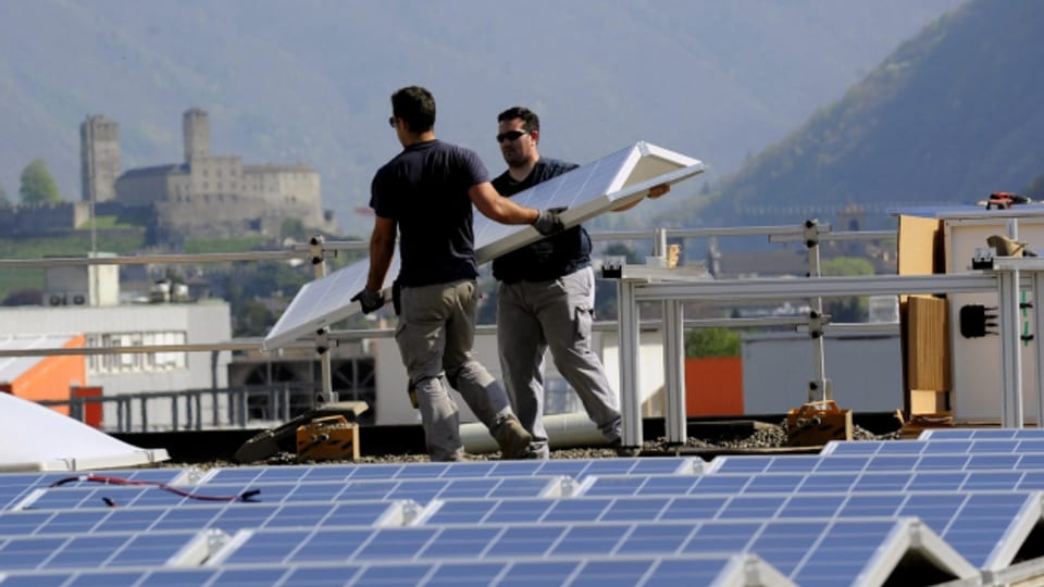 Seltener geworden: Arbeiter installieren Solarpanelen auf einem Dach im Tessin (Archivbild).
