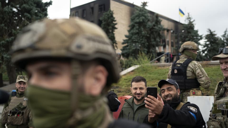 Nach der Rückeroberung der Stadt Izium posiert der ukrainische Präsident Selenski für ein Selfie mit einem Polizeioffizier.