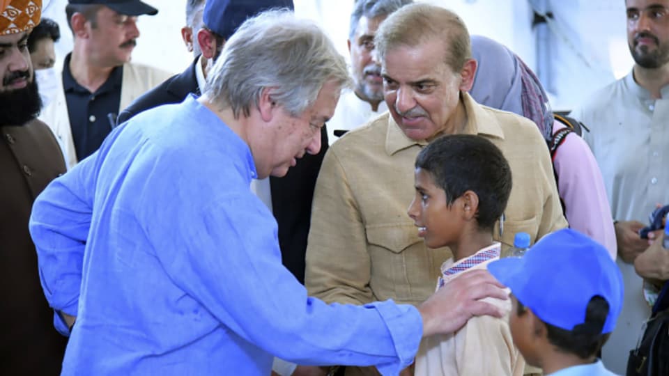 UNO-Generalsekretär Antonio Guterres spricht mit einem Jungen in Pakistan, während einem Besuch überfluteter Gebiete am 10. September.