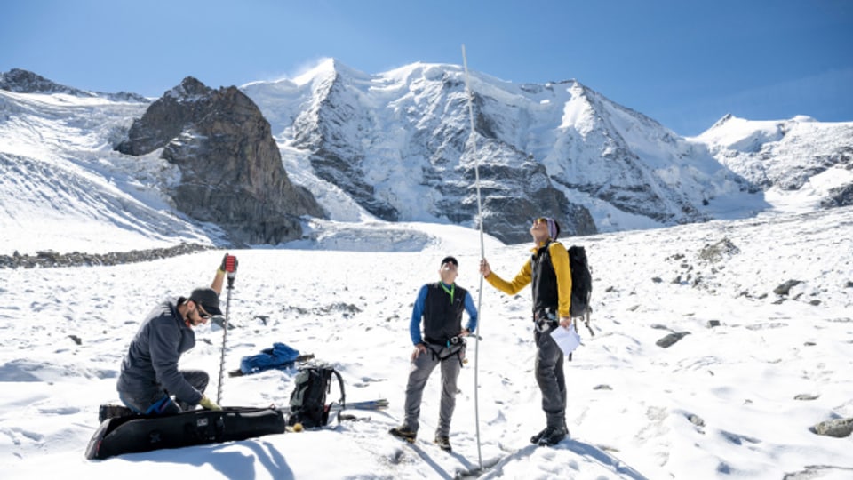Glaziologe Matthias Huss (r.) mit Kollegen der Universität Fribourg und der ETH Zürich beim setzten einer neuen Messstange auf einem Gletscher im Oberengadin.
