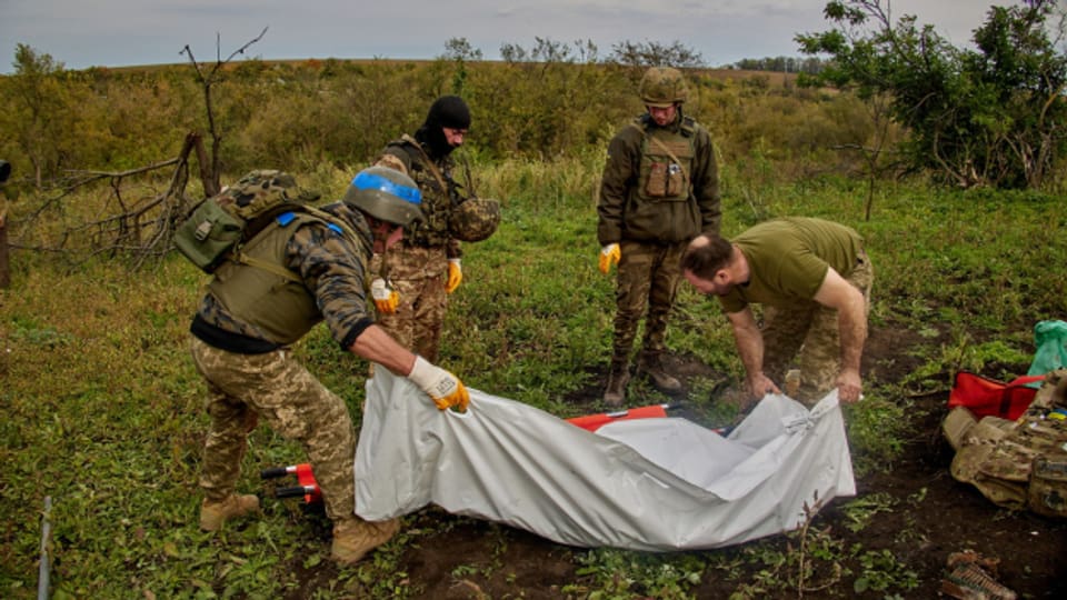 Ukrainische Soldaten exhumieren einen Kameraden bei Dementiivka, nahe Charkiw.