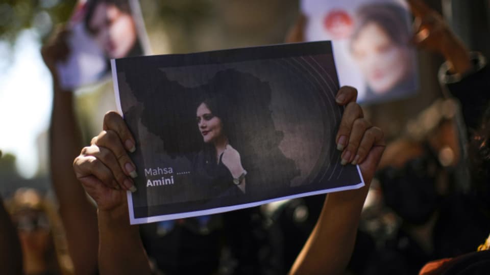 Eine Frau hält ein Foto mit der jungen Iranerin Mahsa Amini während einer Protestaktion.