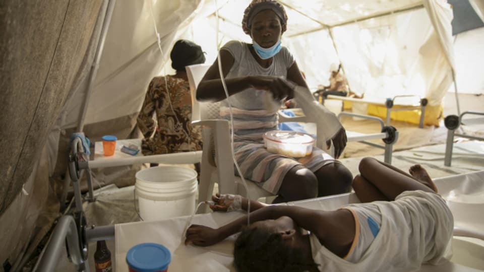 Eine Mutter sitzt an der Seite ihrer an Cholera erkrankten Tochter in einer Klinik in Port-au-Prince.