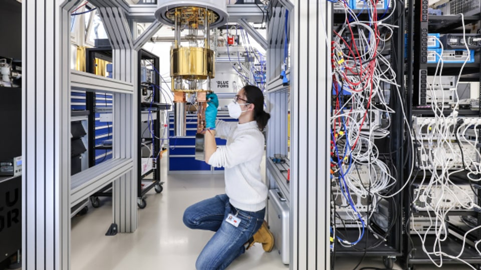Im Forschungszentrum Juelich arbeitet ein Physiker, ein Doktorand, im OpenSuperQ Labs an einem Quantencomputer, hier am Kryostaten der den innen liegenden Quantenchip kuehlt.