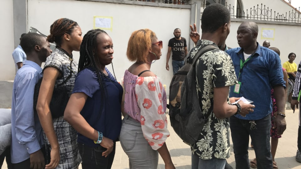 Junge Menschen stehen in Lagos an für ihre Wählerkarte.