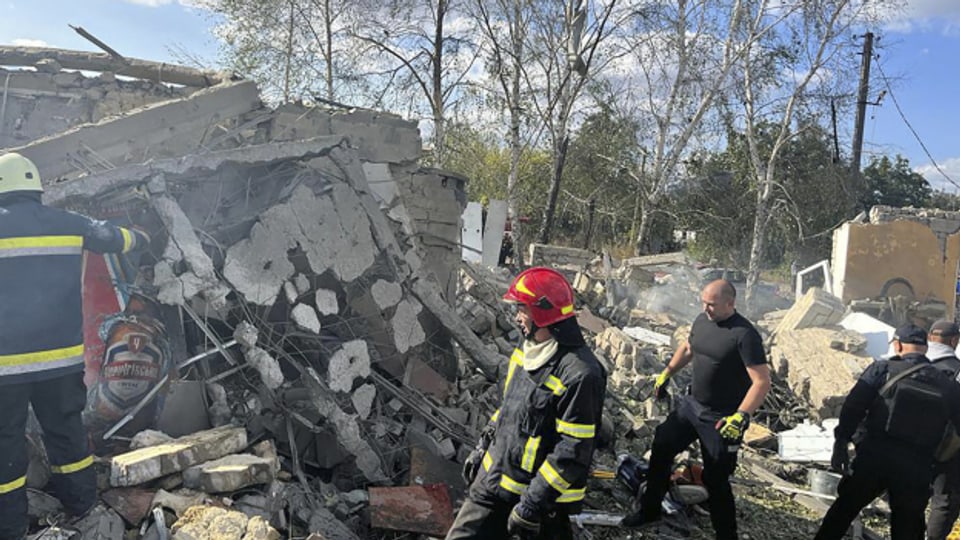 Rettungskräfte in den Trümmern eines zerstörten Hauses.