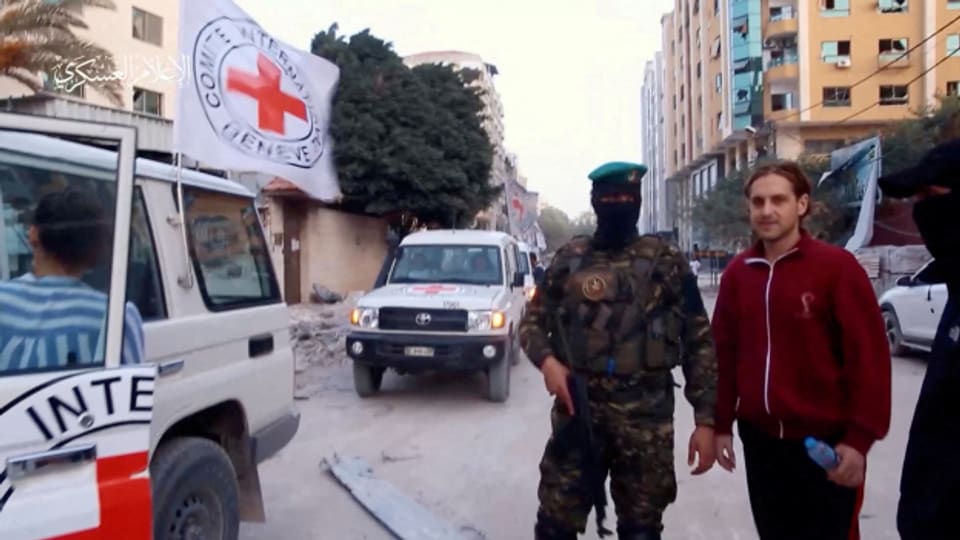 Eine Geisel wird von Hamas-Kämpfern an Mitglieder des Internationalen Komitees vom Roten Kreuz übergeben.