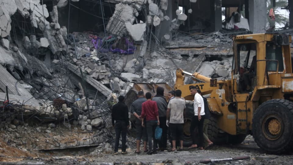 Palästinenser suchen in den Trümmern eines zerstörten Hauses nach Leichen und Überlebenden.