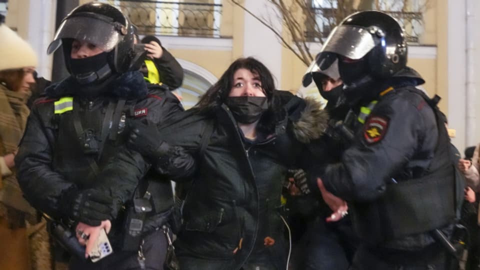Die russische Polizei nimmt nach Kriegsbeginn eine Demonstrantin in St. Petersburg fest.