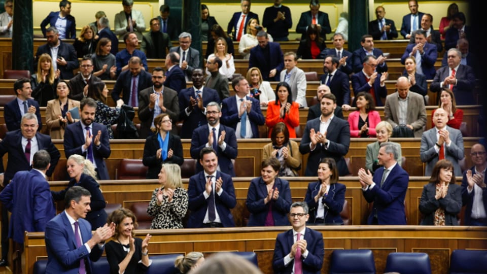 Der spanische Ministerpräsident Pedro Sanchez (L) und Abgeordnete der PSOE feiern die Verabschiedung des sogenannten Amnestiegesetzes am Ende einer Plenarsitzung im Unterhaus in Madrid, Spanien, 14. März 2024.