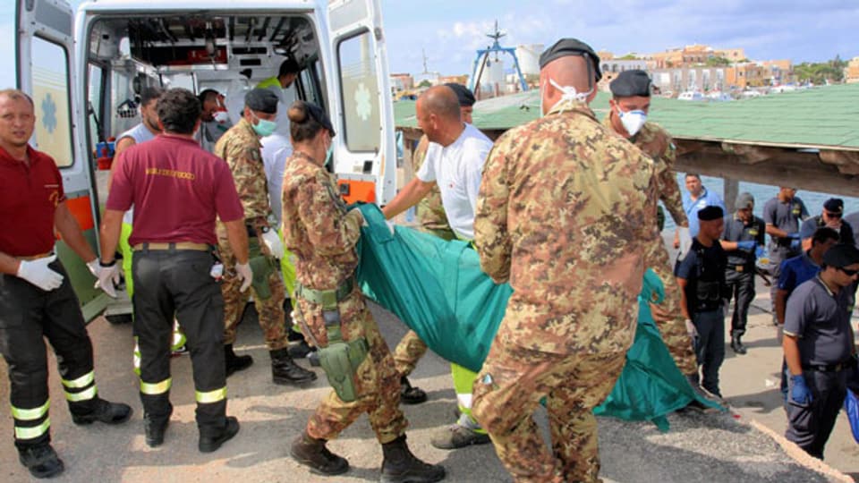  Italienische Rettungskräfte haben angeblich die Leichen von mindestens 93 Menschen, darunter vier Kinder, gefunden. Rund 250 Menschen werden noch vermisst, mindestens 150 konnten lebend gerettet werden.