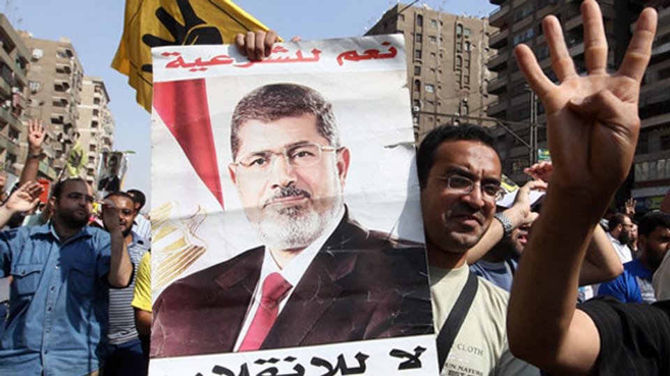 Die Proteste der Muslimbrüder flammen erneut auf. Ein ägyptischer Fan des gestürzten Präsidenten Mohammed Mursi hält ein Plakat von ihm in arabischer Schrift in Kairo, Ägypten, am 4. Oktober 2013.
