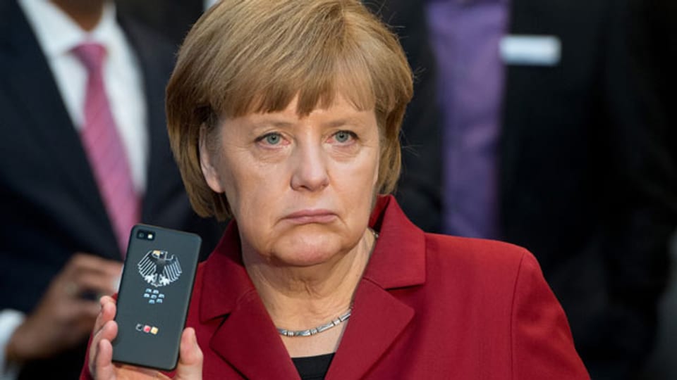Die deutsche Bundeskanzlerin Angela Merkel präsentiert im März 2013 ein abhörsicheres Handy von Blackberry an einem Stand von Secusmart während der Computermesse CeBIT in Hannover expo.