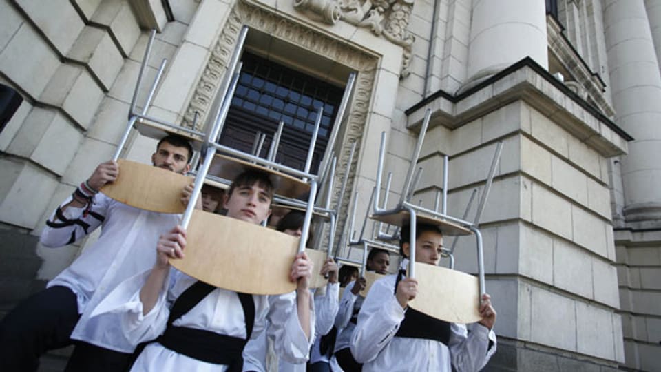 Eine Gruppe von bulgarischen Studenten tragen Stühle auf dem Kopf während einer Protestaktion vor der Universität Sofia in Sofia . Archivbild.