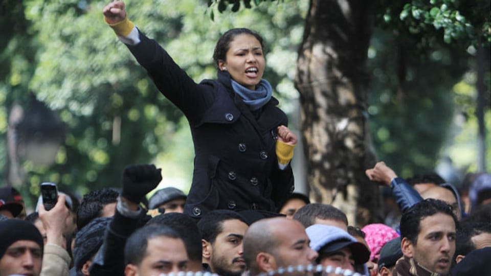 Eine junge Frau hebt ihre Faust bei einer Demonstration in Tunis.
