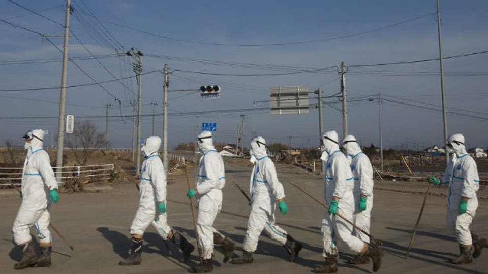 Japanische Polizisten in Schutzanzügen am 7. April 2011 suchen nach Opfern der Nuklear-Katastrophe von Fukushima