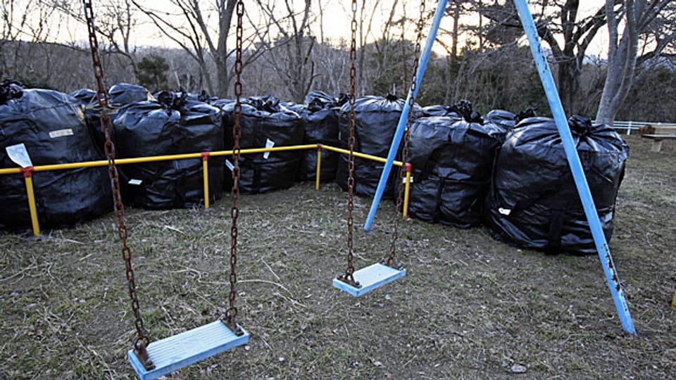Ein Dorf in der Nähe des AKW Fukushima, In den schwarzen Plasticsäcken wird verseuchter Abfall gesammelt.