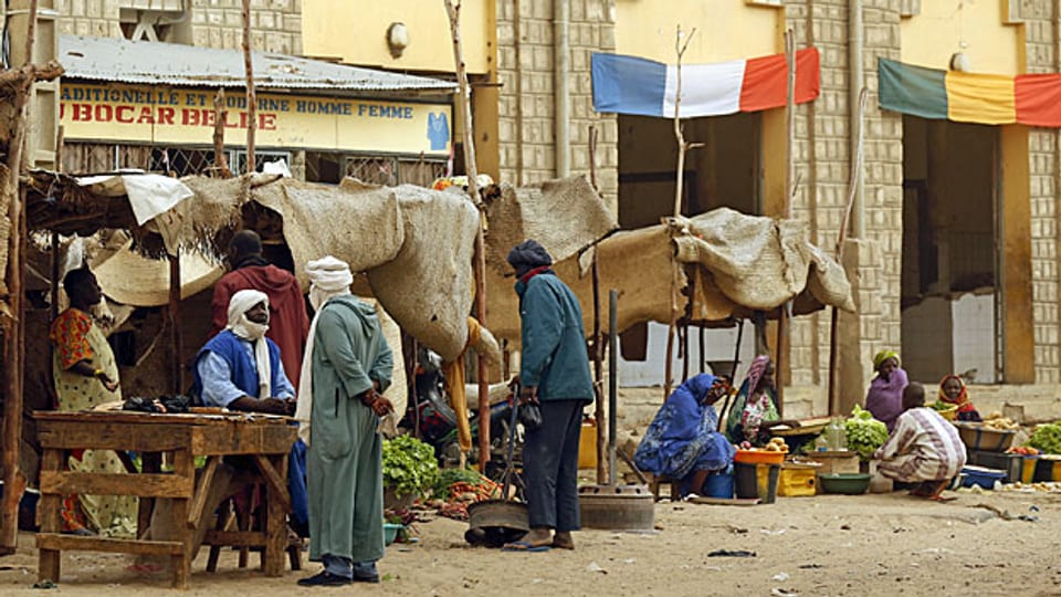 Eine Strasse in Timbuktu; eine französische und eine malische Flagge über zwei Haustüren.