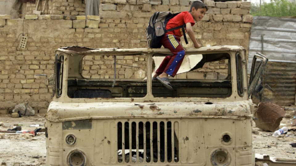 Überreste des Krieges im Irak: Kind spielt auf einem ausgebombten Lastwagen.