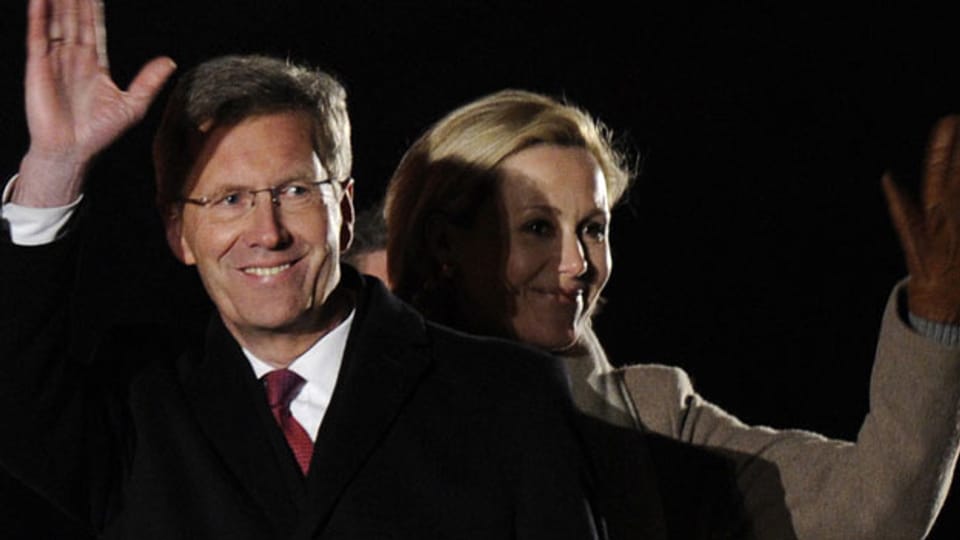 Der ehemalige Bundespräsident Christian Wulff winkt am 8.3.2012 vor Schloss Bellevue in Berlin neben seiner Ehefrau Bettina.