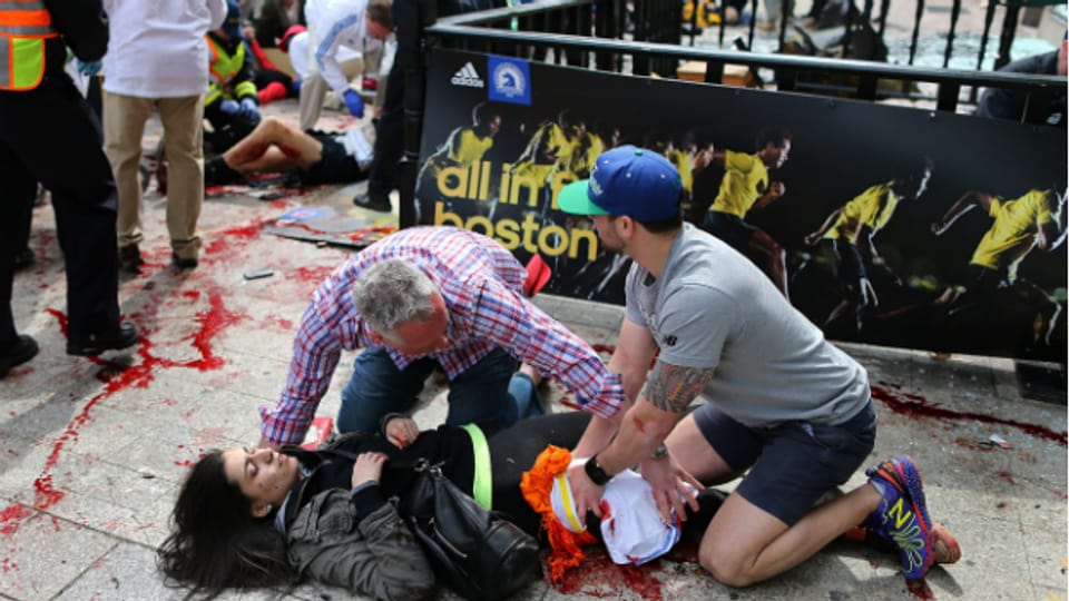 Anschlag in Boston: Helfer kümmern sich am Marathon um eine verletzte Frau.