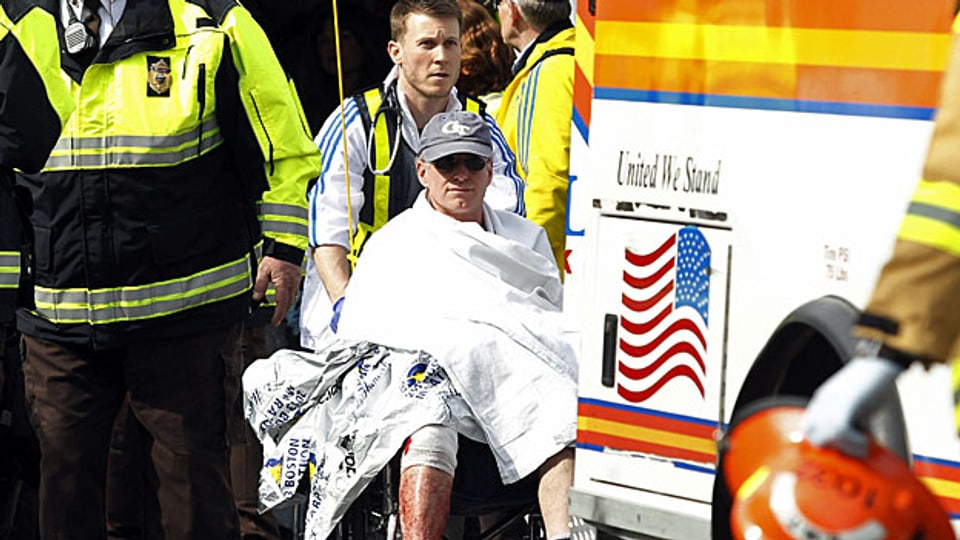 Ein verletzter Läufer im Rollstuhl, nach dem Bombenanschlag auf den Boston Marathon.