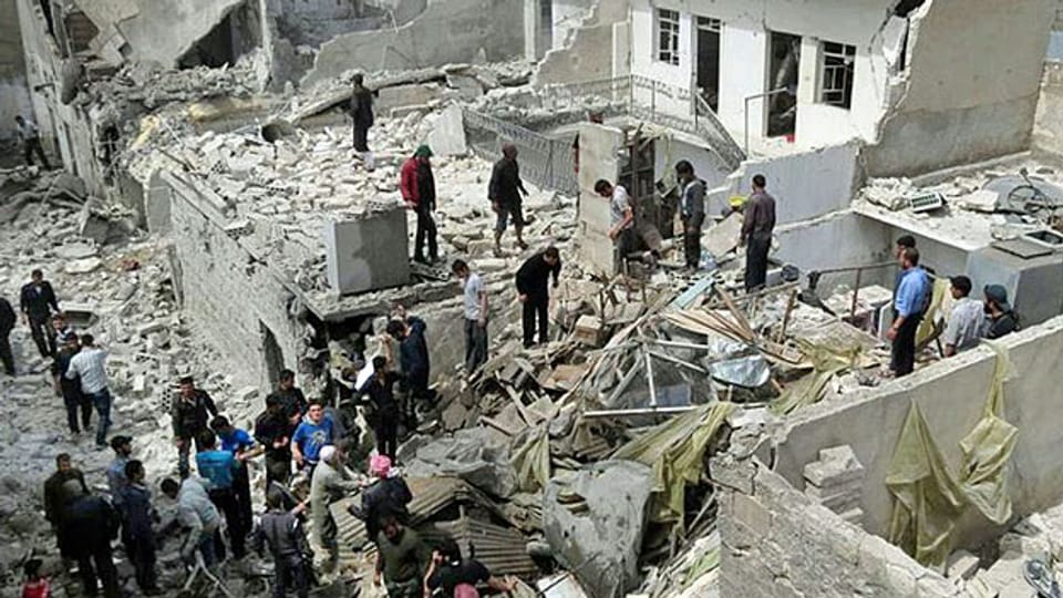Bewohner Aleppos vor Häusern, die durch einen Angriff der syrischen Luftwaffe zerstört wurden.uft