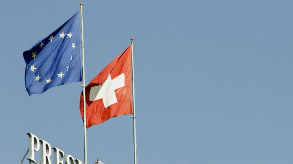 Die Schweizerfahne und die Fahne der EU auf dem Dach des Hotels Wilson in Genf