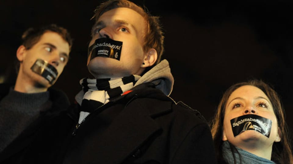 Aktivisten protestieren mit verklebtem Mund gegen das neue Mediengesetz der ungarischen Regierung während einer Demonstration am 11. Januar 2011 in Budapest.