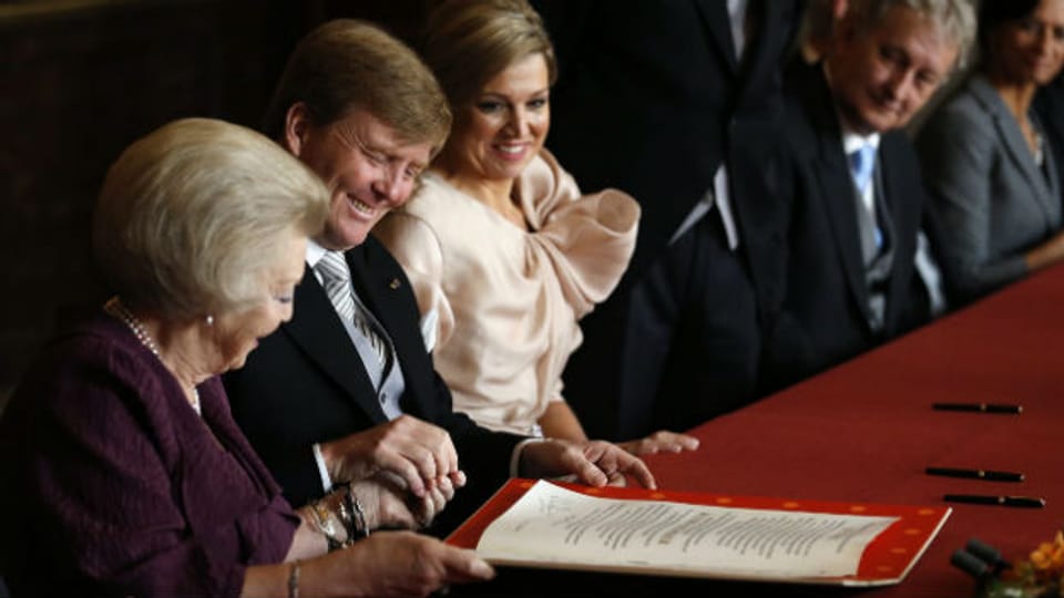 Königin Beatrix unterzeichnet ihre Abdankungsurkunde.