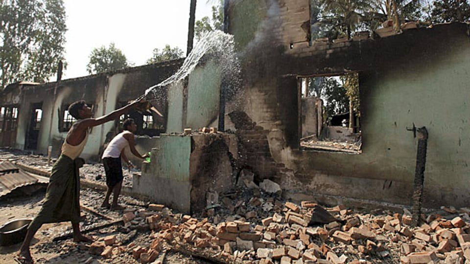 Die Bevölkerung versucht, das Feuer in einer zerstörten Moschee zu löschen, in Okkan, etwa 60 Kilometer von Burmas Hauptstadt Rangun entfernt.