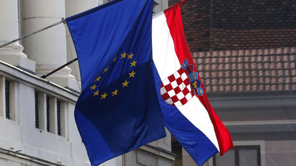 Flaggen der Europäischen Union, links, und von Kroatien fliegen auf dem Parlamentsgebäude in Zagreb, Kroatien, amSonntag, 22. Januar 2012.