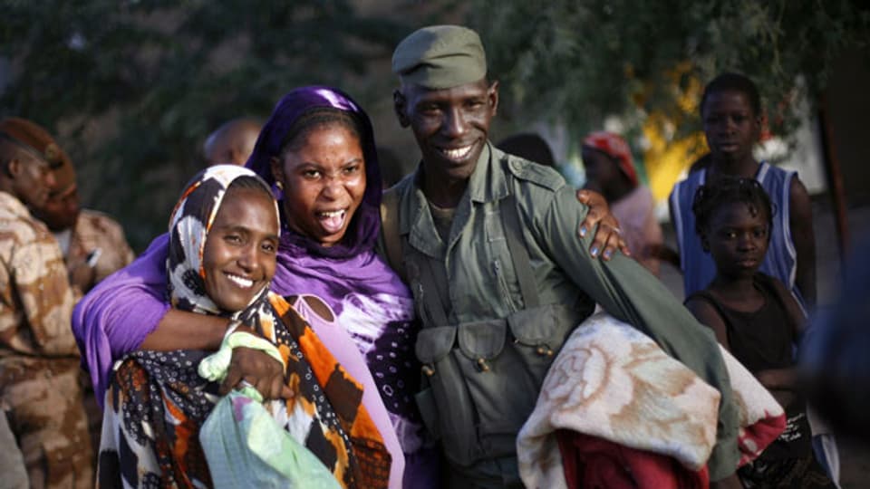 Malischen Frauen posieren mit einem malischen Soldaten. Besonders die Frauen litten unter den radikalen Islamisten.