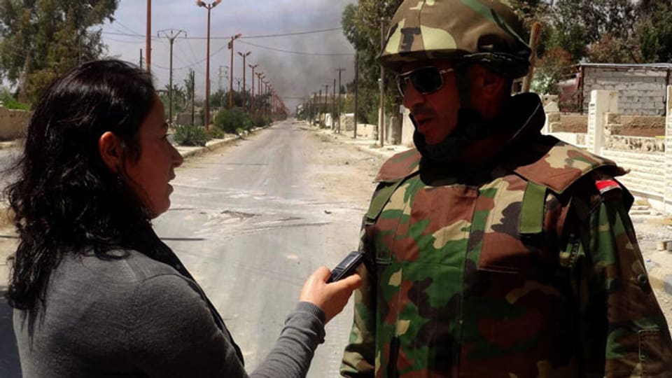 Ein syrischer Offizier spricht mit einer Journalistin während einer Patrouille in Otaiba Stadt im ländlichen Damaskus, Syrien, am 24. April 2013.